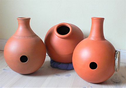 Drei erdfarbene Udu-Trommeln - runde Gefäße mit Loch und einem offenen Flaschenhals